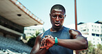 Athlete, black man and check watch at stadium for running speed, fitness stats and workout performance. Runner, sweating and wristwatch outdoor for tracking heart rate, marathon progress and lap time