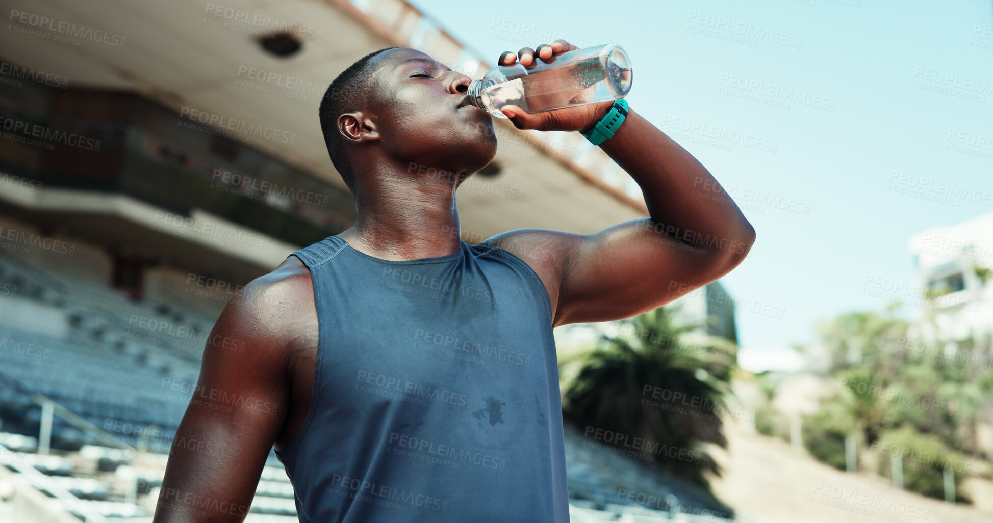Buy stock photo Stadium, black man and fitness with drinking water for wellness, hydration and nutrition on workout break. Outdoor, male person and athlete with bottle for h2o liquid, detox and beverage for exercise