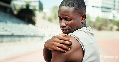 Buy stock photo Black man, stadium and pain in shoulder with fitness, muscle sprain or tension in ligament. Athlete, runner and outdoor for sport with exercise mistake, joint injury and massage for relief in Nigeria