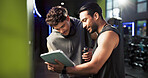 Men, personal trainer and tablet with talking at gym with smile, sign up and listening with exercise tips. People, coach and touchscreen with app for training, registration or offer at fitness center
