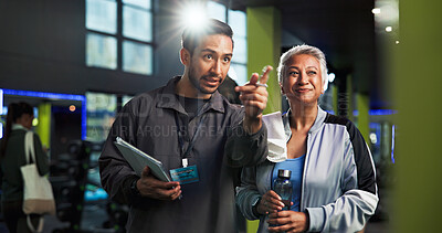 Buy stock photo Talking, man and personal trainer with woman, smile and showing workout progress, fitness and online. Health club, people and explaining training routine to mature client, instructor and tech in gym