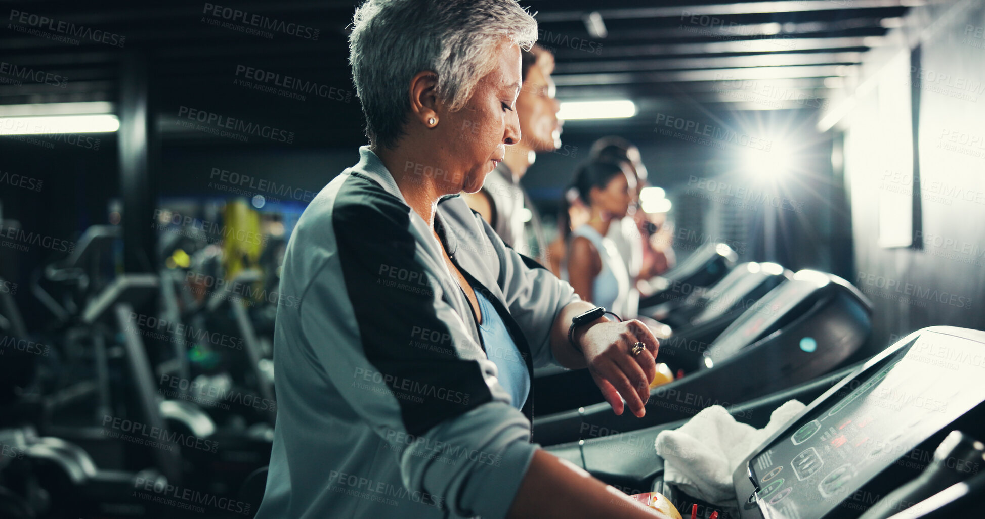 Buy stock photo Runner, smart watch and fitness with woman on treadmill for speed timer, workout and training stats. Performance tracking, cardio and wellness with mature person on running machine for endurance
