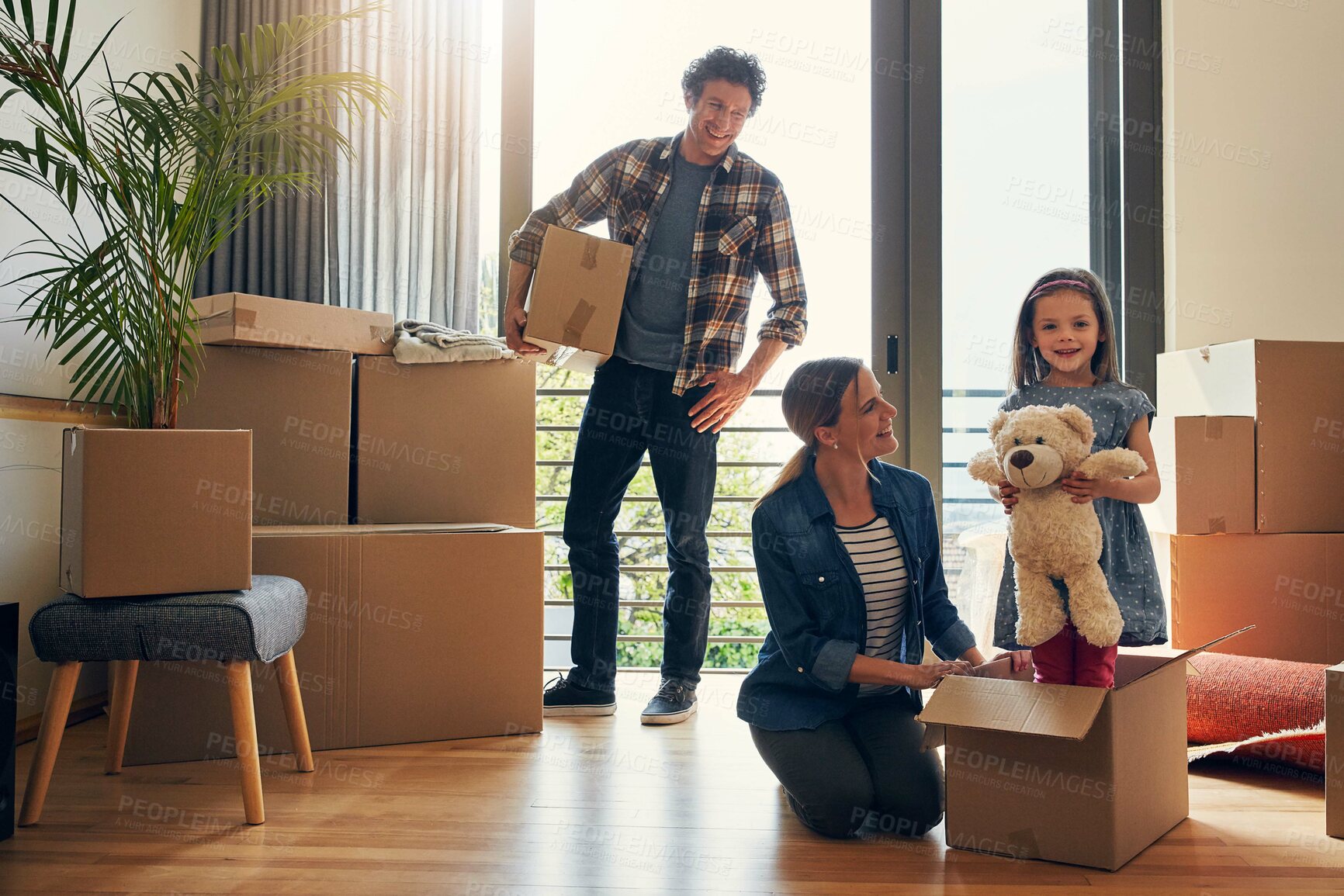 Buy stock photo Moving, parents and portrait of child in new home bonding together for family time with teddy bear. Happy, mortgage and girl kid play with mom and dad for fun and unpacking cardboard boxes for house.