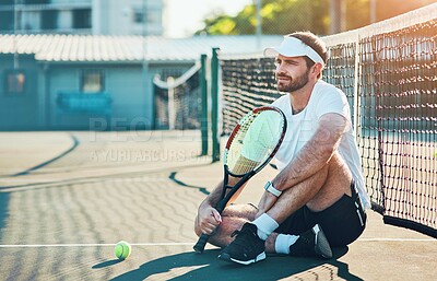 Buy stock photo Man, relax and break with racket for tennis match, game or sport on floor by net at court. Young, male person or athlete with bat or ball for rest or half time in competition or outdoor tournament