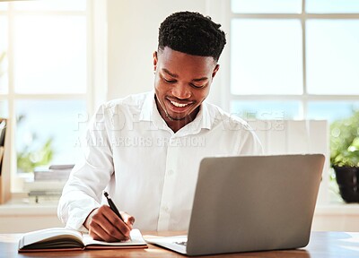 Buy stock photo Internet, laptop and black man writing in notebook, happy freelance worker. African businessman with smile doing online research, taking notes for startup idea or project at desk and in modern office
