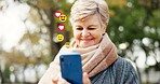 Elderly, happy woman or social media icons with phone in nature for online reaction or feedback. Senior, female person or user with smile on mobile smartphone for connection, communication or network