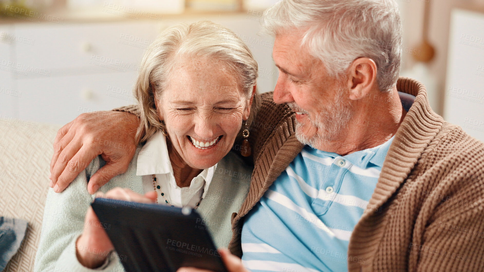 Buy stock photo Senior couple, tablet and happy on sofa in home with hug, laughing and relax with film in living room. Elderly man, woman and digital touchscreen with app for movies, comedy and video in retirement