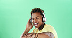 Portrait, headphones and happy black man on green screen with music, mockup space or smile. Good mood, song audio or excited model dancing to celebrate with rhythm, positive energy or streaming sound