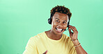 Happy, headset and african man talking in studio for call center, customer service and green background. Contact us, technical support and operator for help desk, troubleshooting and inquiry by space