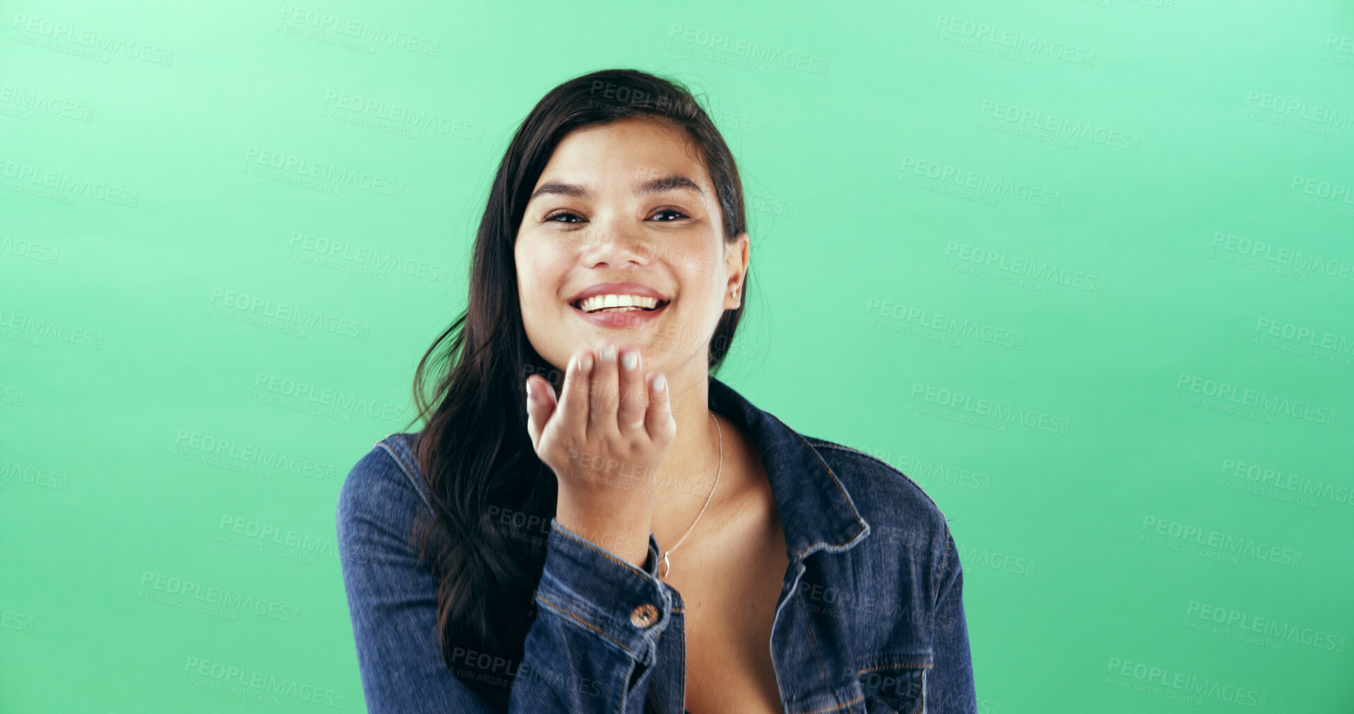 Buy stock photo Portrait, woman and blow kiss in studio for flirting, show attraction and romantic gesture. Mockup space, female person and smile for love emoji on valentines day, affection sign and green background