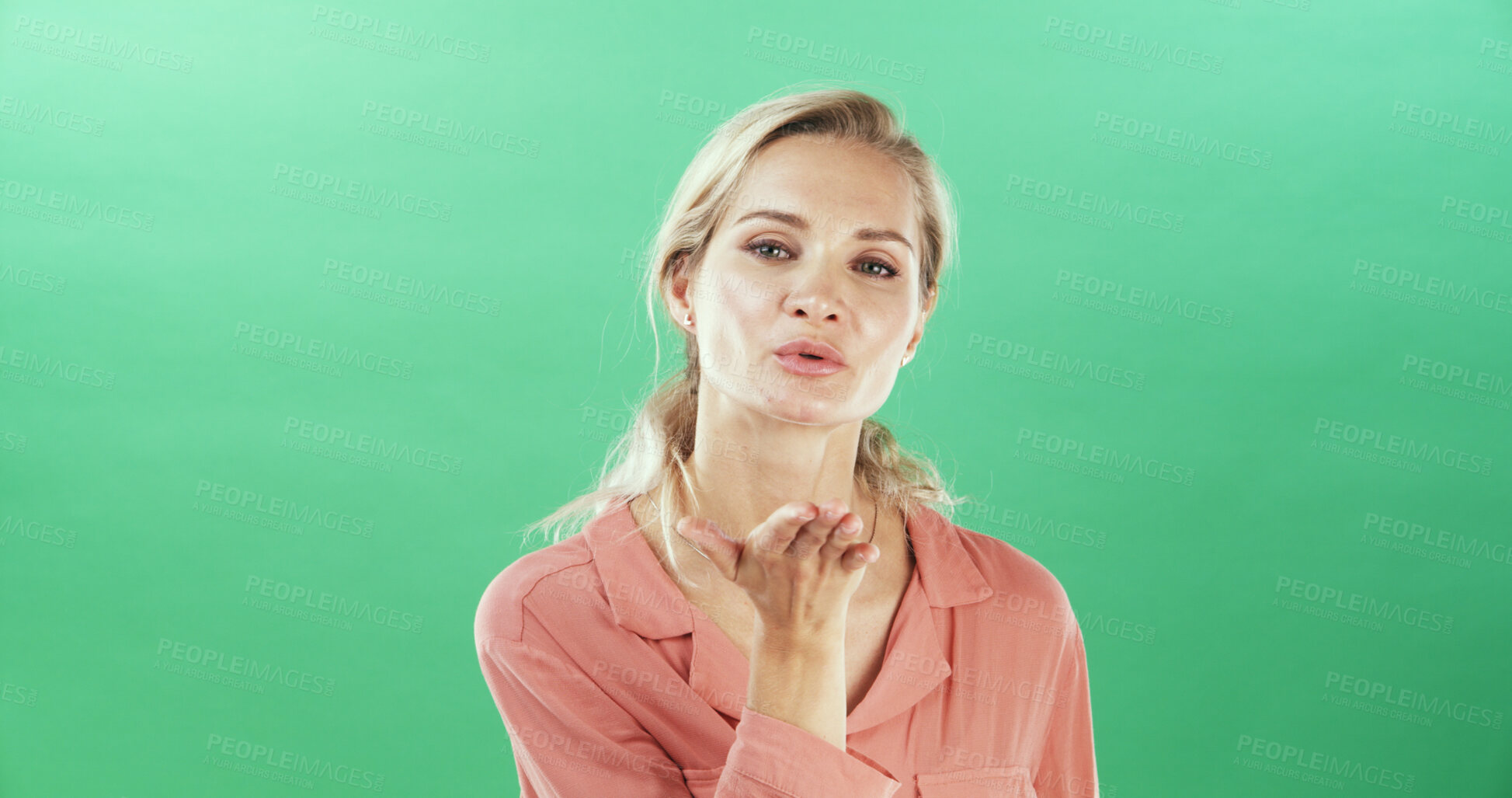 Buy stock photo Portrait, woman and blowing kiss for flirting, show attraction and romantic in studio. Mockup space, female person and gesture with love emoji on valentines day, affection symbol and green background