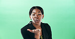 Black woman, portrait and blowing with kiss for love or care in studio on a green background. Face, female person or model with romantic gesture for affection, distance or kindness on mockup space
