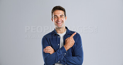 Buy stock photo Pointing, offer and man in studio, portrait and announcement discount deal on gray background. Person, mockup space and model with hand gesture, opportunity and choice with sales, decision and smile