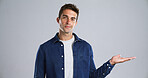 Portrait, man and palm with presentation in studio for advertising, offer deal or announcement. Launch, ambassador and show marketing space for about us, coming soon or opportunity on gray background