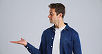 Marketing, man and palm with presentation in studio for offer deal, about us and announcement. Launch, ambassador and show advertising space for coming soon, feedback and sale news on gray background