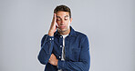 Tired, headache and man in studio, stress and burnout with muscle tension on gray background. Fatigue, person and model with migraine, anxiety and mental health with pressure, frustrated and pain