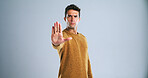 Man, portrait and stop with hand out in studio for rejection, no or halt on a white background. Male person, model or disapproval with palm for warning, termination or cease fire on mockup space