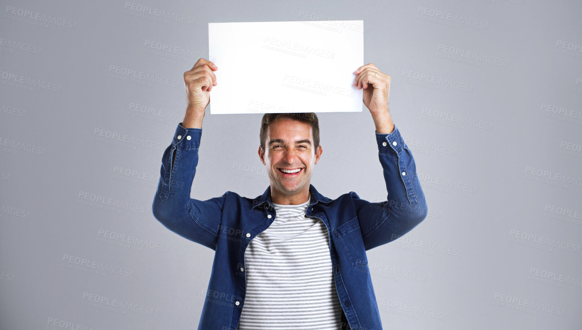 Buy stock photo Portrait, man and laugh with poster in studio for billboard, branding flyer and announcement. Smile, mockup space and show signage with person, news information and message notice on white background