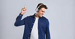 Music, headphones and man with dancing for fun, online streaming or radio with mockup space in studio. Energy, listening with audio tech and sound for rhythm with male person on white background