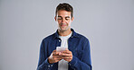 Smile, mobile and man in studio for text, typing or reading message on white background. Phone, happy person and check email online on app for forum post, play game or social media with mockup space