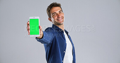Buy stock photo Man, portrait and phone with green screen in studio for website, mockup space and white background. Student person, user or model with smile, smartphone and software app for university schedule