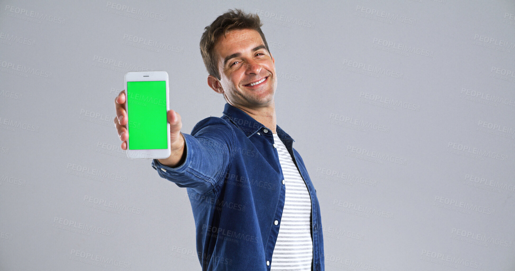 Buy stock photo Man, portrait and phone with green screen in studio for website, mockup space and white background. Student person, user or model with smile, smartphone and software app for university schedule