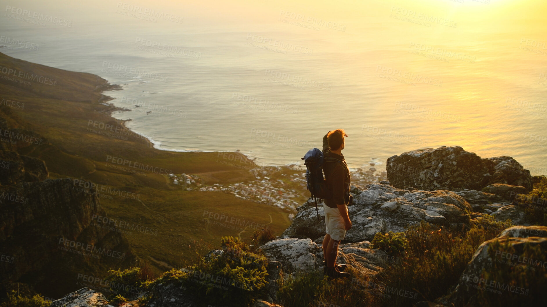 Buy stock photo Man, hiking and view at sunset with ocean, rocks or backpack for nature in summer. Person, perspective and sightseeing by sea, mountain summit and cliff with trekking, outdoor and tourism in Greece