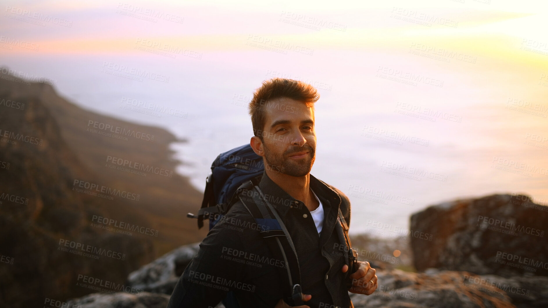 Buy stock photo Hiking, backpack and man with portrait on mountain for trekking adventure, break or explore nature. Sunrise, smile and person with ocean view for travel, backpacker journey and relax at destination