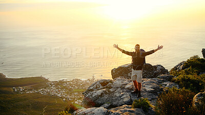 Buy stock photo Ocean, mountains and man with open arms, sunset and excited with fitness, challenge and nature. Environment, hiker and person with freedom, hiking and seaside with break, portrait or trekking