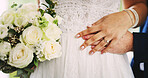 White roses, wedding and couple holding hands for love, care or support at event. Bouquet, man and woman with flowers for marriage ceremony, bride and groom celebrate commitment with romantic partner