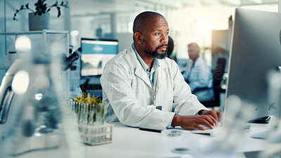 Buy stock photo Computer, biology and medical with man in laboratory for online development, research or science. Healthcare, innovation and typing with mature scientist at desk for breakthrough or experiment