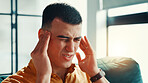 Home, headache and man on sofa, pain and stress with crisis, dehydration and massage temple. Apartment, burnout and person on couch, migraine and pressure with fatigue, mental health and discomfort