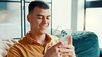 Phone, relax and weekend with man on sofa in living room of home for break or internet browsing. App, social media and text message with happy person in apartment for communication or search