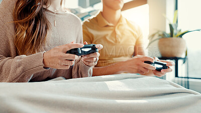 Buy stock photo Dating, gaming and hands of couple on sofa in living room of home together for entertainment or fun. Blanket, bonding and remote controller with gamer people closeup in apartment for competition