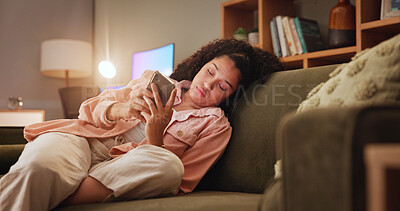 Buy stock photo Woman, bored and phone with texting on sofa, tired and doom scroll with subscription on social media. Girl, smartphone and click on mobile app at night, chat and annoyed on couch in lounge at house
