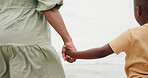 Holding hands, parent and child by ocean on vacation with care, love and bonding in nature. People, kid and support with connection, outdoor and holiday for family with back, beach and getaway by sea