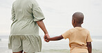 Holding hands, parent and boy by ocean on vacation with care, love and bonding in nature. People, child and support with connection, outdoor and holiday for family with back, beach and getaway by sea