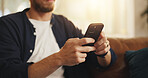 Hands, sofa and man with phone in home for social media, online networking and chat on mobile app. Apartment, typing and person on smartphone for internet, contact and message notification on weekend