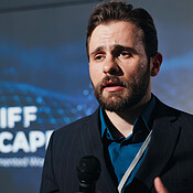 Man, speaker and mic for speech at conference for tariff landscape of ...