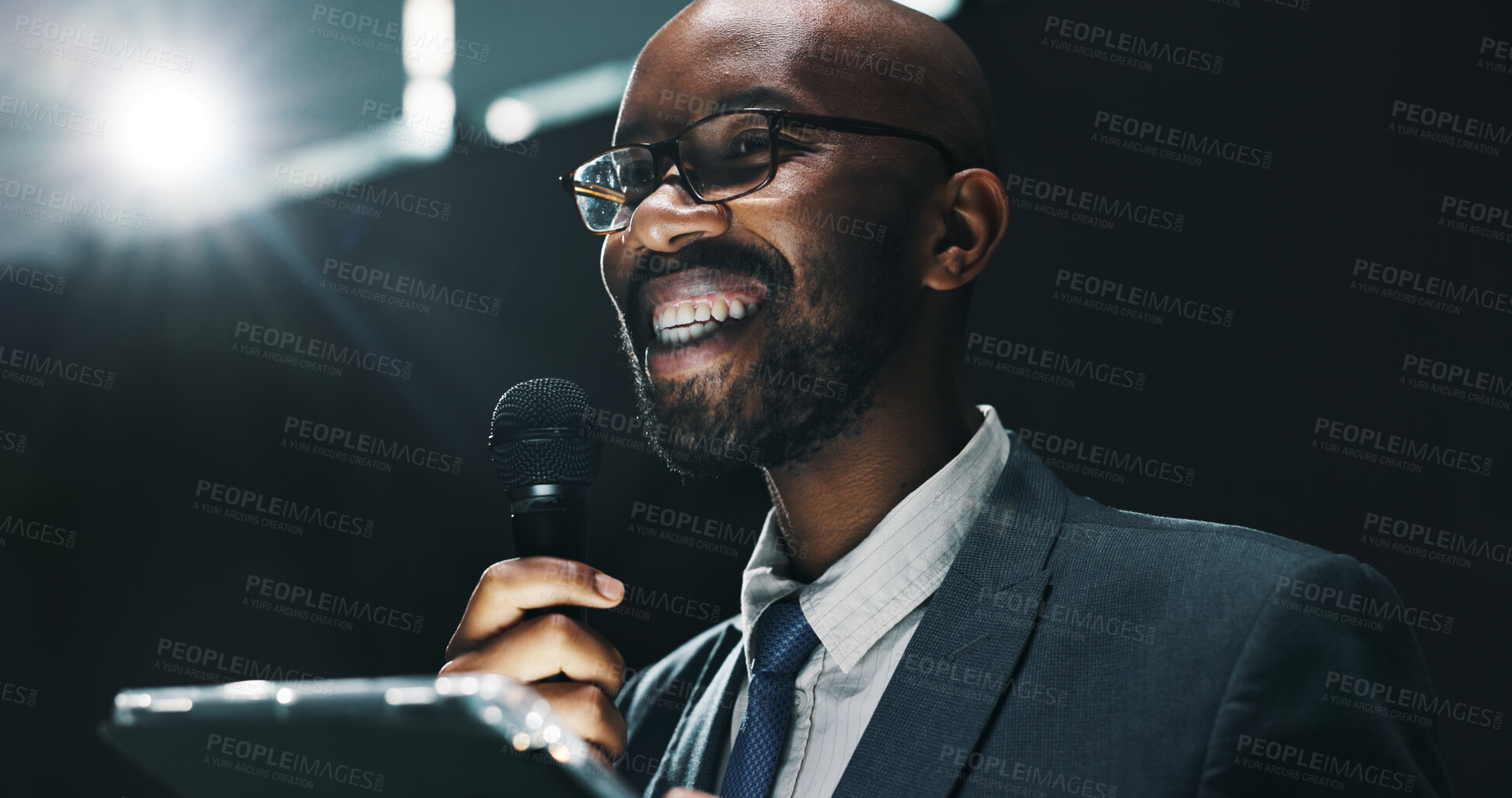 Buy stock photo Microphone, speech and tablet with business black man at symposium for announcement or development. App, event and stage with happy African speaker in auditorium for coaching or training conference