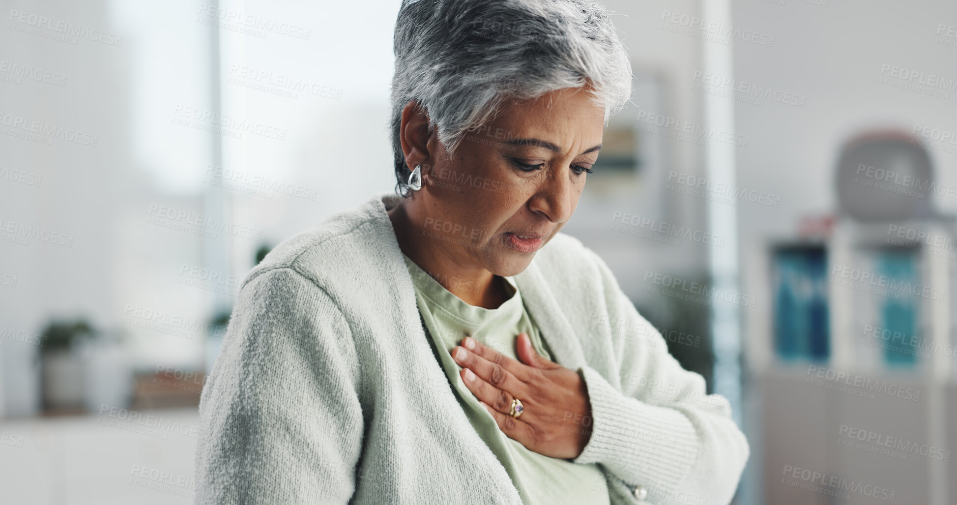 Buy stock photo Senior, sick woman and chest pain with heartburn at hospital for clinic checkup, visit or exam. Mature, female person or infection with virus or symptoms for discomfort, acid reflux or gastro disease