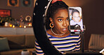 Black woman, ring light and live streaming with talk in home, chat and recording in living room. Girl, video and gen z influencer with mobile app, social media and content creation at night in house