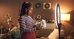 Unboxing, website and woman with ring light, home and influencer with product to review or creative. Live stream, content creator and black person with package for social media, app or promo at night