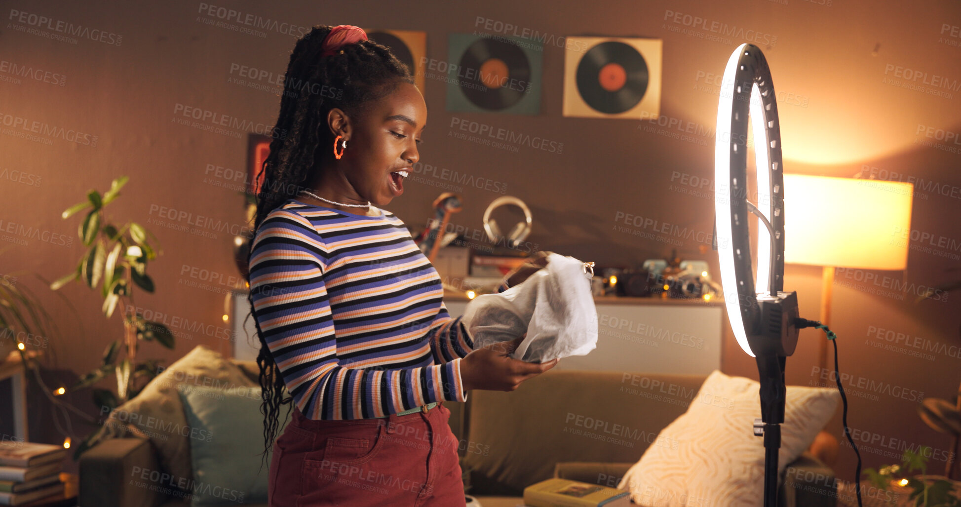 Buy stock photo Unboxing, website and woman with ring light, home and influencer with product to review at night. Live stream, content creator and black person with package for social media, late update or video
