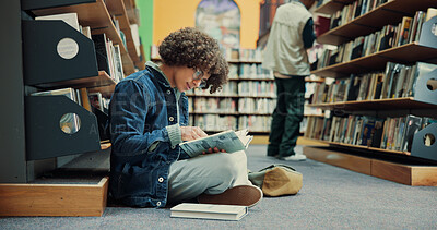 Buy stock photo Student, textbook and man in library with reading, assignment or thesis research on ground. Information, studying and male person with education, prepare for exam or learning on university campus