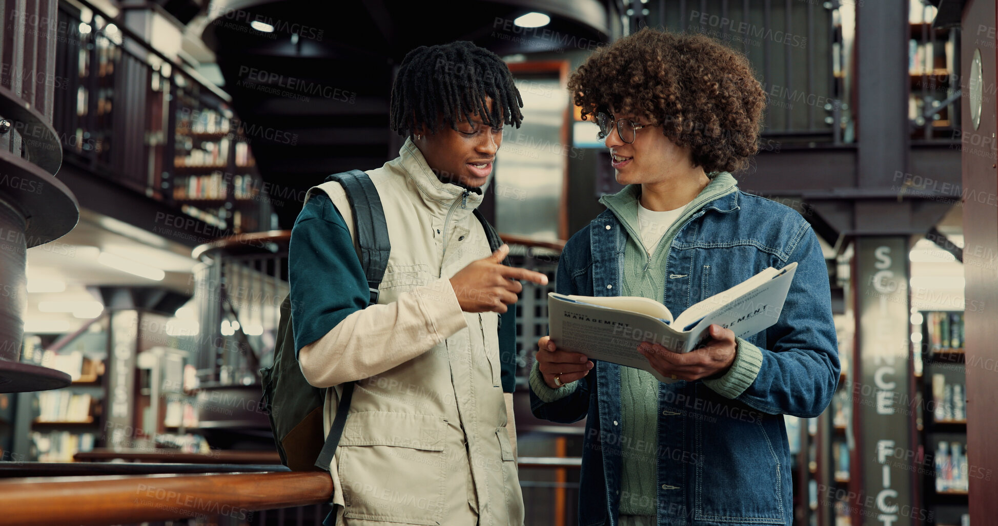 Buy stock photo Men, students and book for education in library by studying, information and prepare for exams. People, friends and reading textbook for research, knowledge and learning for assignment of scholarship