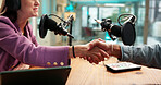 Talk show interview, host or guest with handshake in studio for welcome, podcast or live broadcast. Radio production, content creation and person shaking hands with influencer for greeting and hello