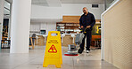 Cleaning, hygiene and caution for wet floor, sign and person with equipment for service or business. Board, information and warning for safety, disinfection and routine for sanitation of coffee shop