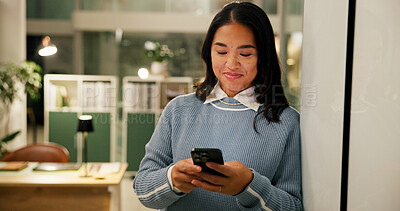 Buy stock photo Happy, cellphone and businesswoman in office at night with communication for overtime on creative project. Smile, phone and Asian magazine editor with mobile app for contact with publishing deadline.