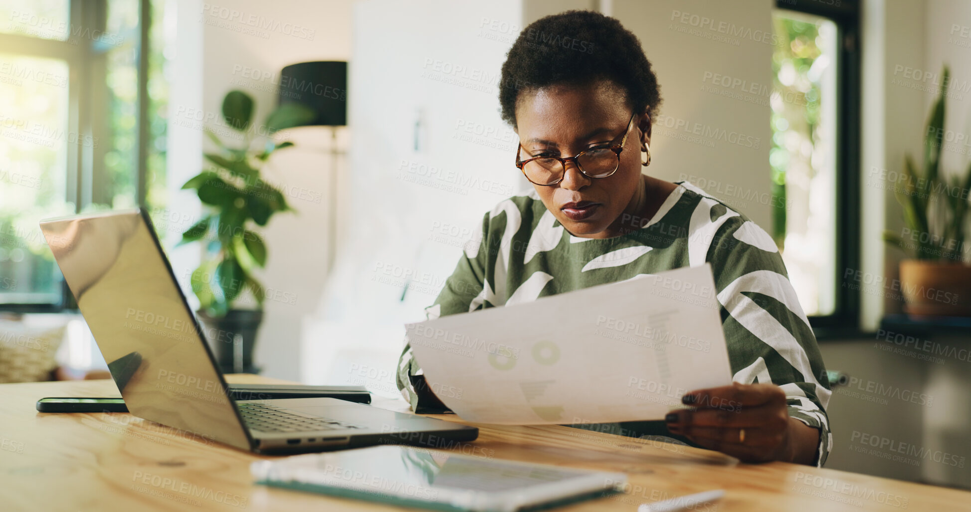 Buy stock photo Reading, paperwork and woman with laptop, freelance and data analysis with tech, accountant or home. Review, financial report and black person with documents for bookkeeping, remote work and house